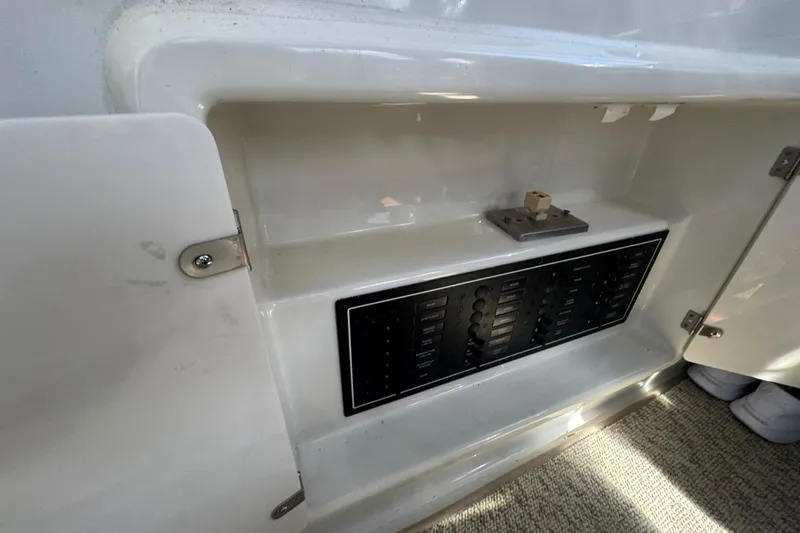 Slide: The Image of Electrical panel inside 2004 Carver 564 Cockpit Motor Yacht, featuring multiple switches and controls. - 26