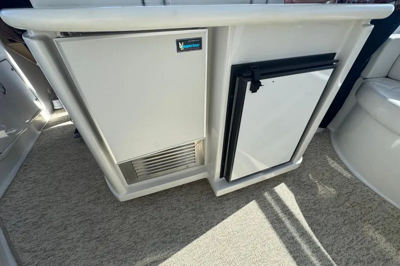 Slide: The Image of 2004 Carver 564 Cockpit Motor Yacht interior with built-in refrigerator and storage. - 27