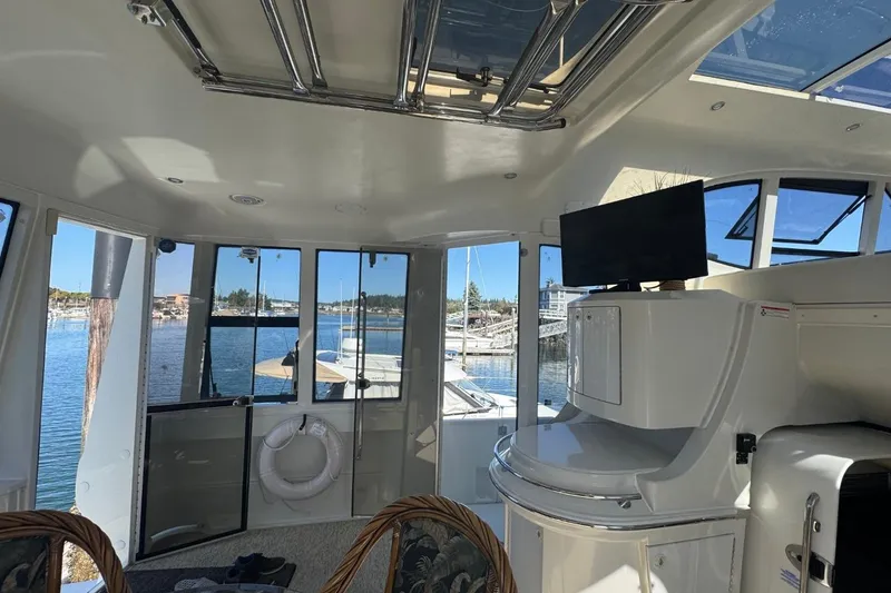 Slide: The Image of Interior view of 2004 Carver 564 Cockpit Motor Yacht with marina backdrop. - 29