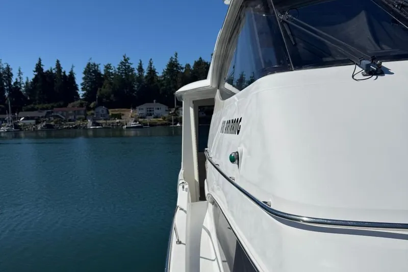 Slide: The Image of 2004 Carver 564 Cockpit Motor Yacht docked by serene waterfront homes. - 3