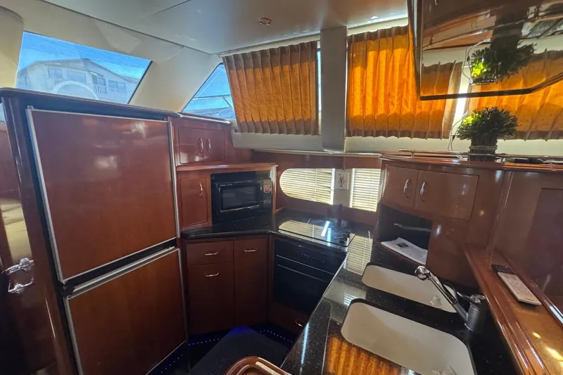 Slide: The Image of Luxurious kitchen interior of 2004 Carver 564 Cockpit Motor Yacht with wood cabinetry. - 34