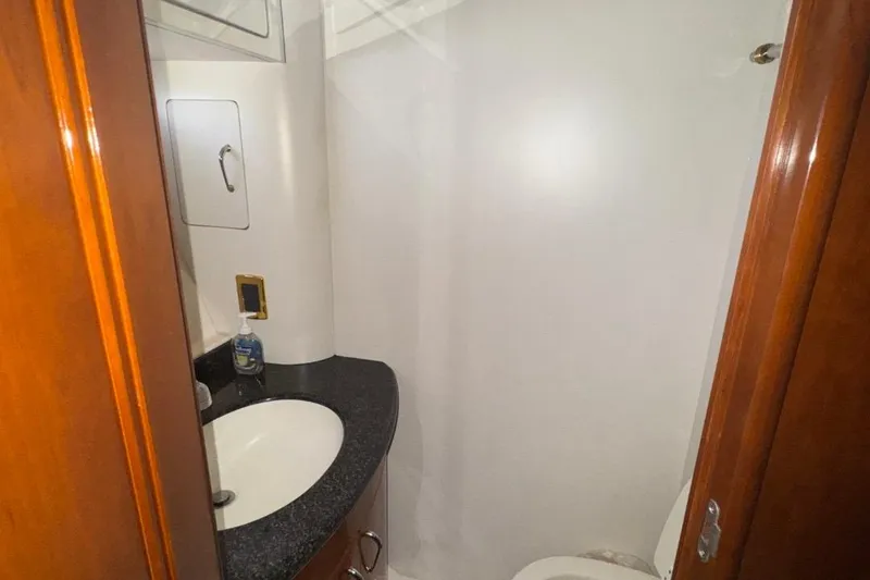 Slide: The Image of Bathroom interior of 2004 Carver 564 Cockpit Motor Yacht with sink and wooden cabinetry. - 41