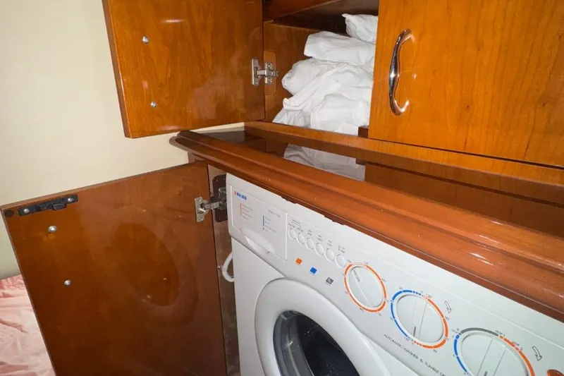 Slide: The Image of Laundry area inside 2004 Carver 564 Cockpit Motor Yacht with wooden cabinetry. - 42