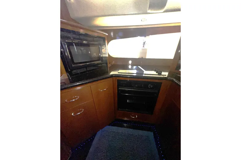 Slide: The Image of Interior of 2004 Carver 564 Cockpit Motor Yacht kitchen with microwave and oven. - 47