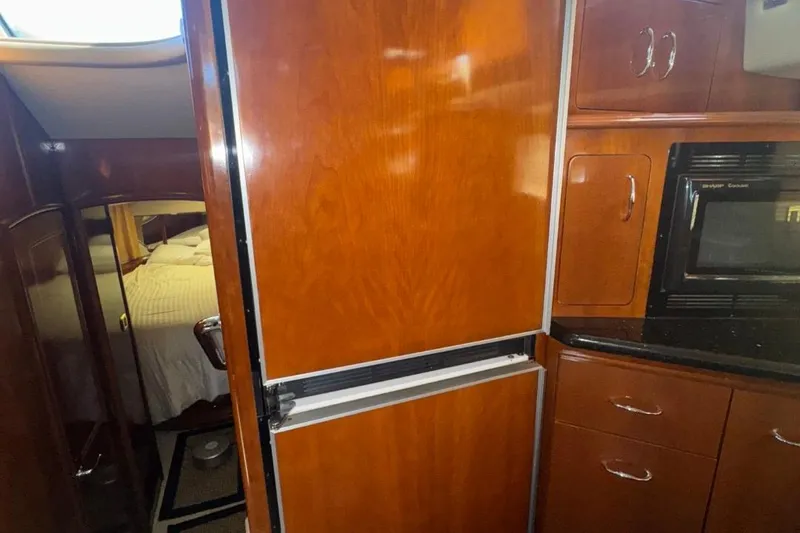 Slide: The Image of Interior of 2004 Carver 564 Cockpit Motor Yacht with wood cabinetry and modern appliances. - 48