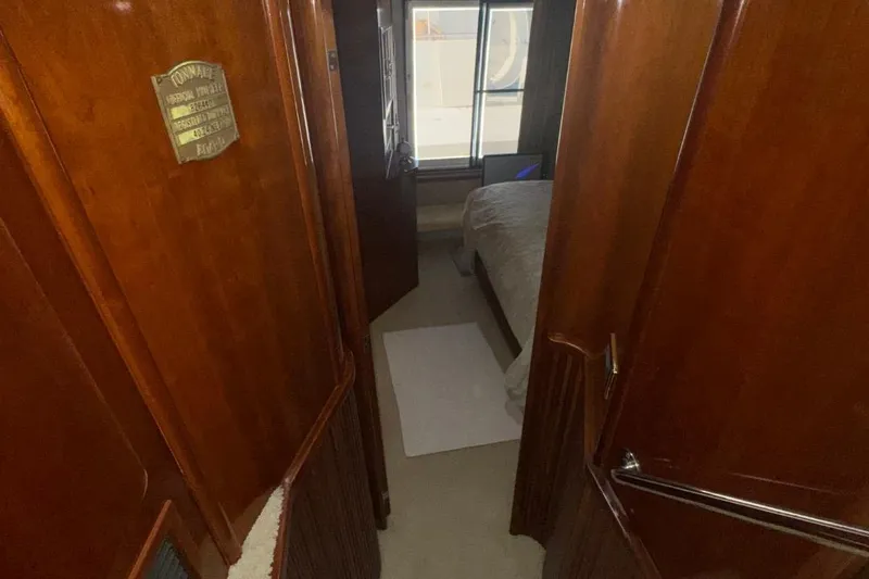 Slide: The Image of Interior hallway of 2004 Carver 564 Cockpit Motor Yacht with wooden paneling and bedroom view. - 51