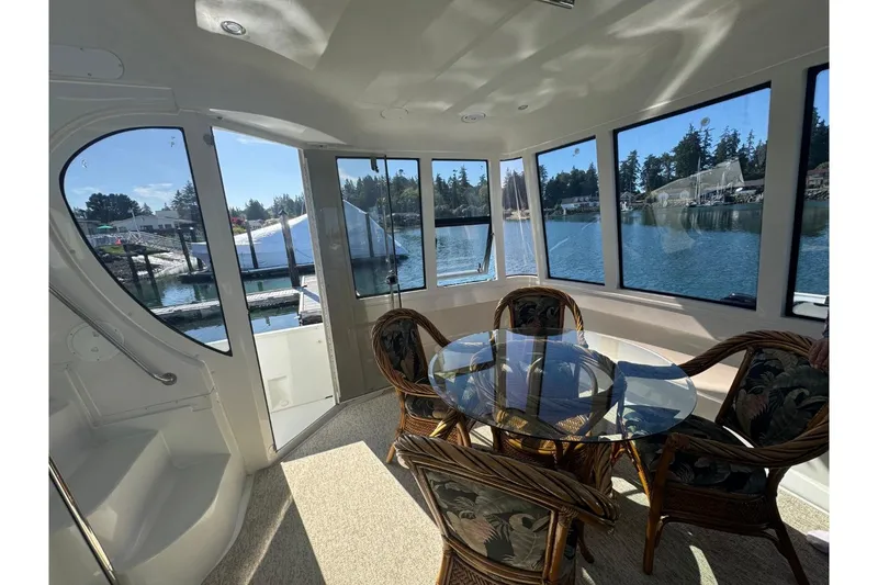 Slide: The Image of Interior of 2004 Carver 564 Cockpit Motor Yacht with glass table and scenic water view. - 6