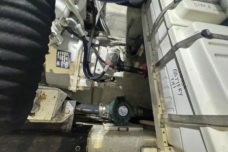 Slide: The Image of Engine compartment of 2004 Carver 564 Cockpit Motor Yacht, showing mechanical components and battery. - 66