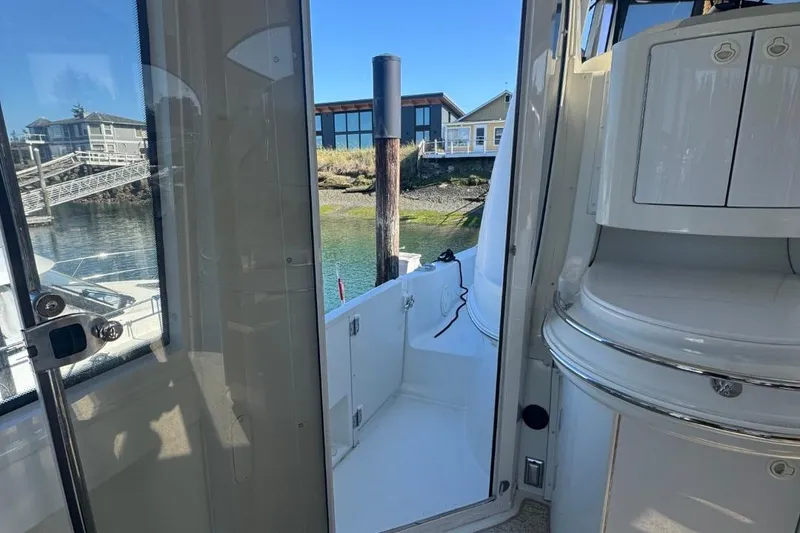 Slide: The Image of 2004 Carver 564 Cockpit Motor Yacht interior view with open door to deck. - 7