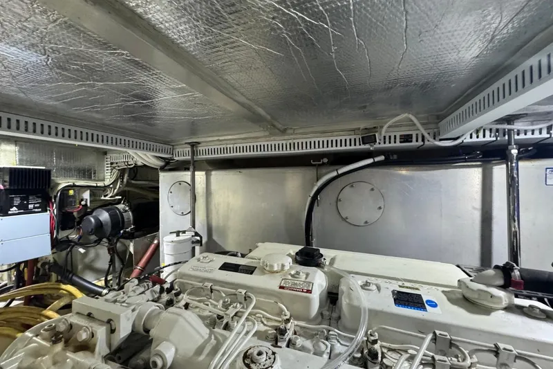 Slide: The Image of Engine room of 2004 Carver 564 Cockpit Motor Yacht, showcasing mechanical components and wiring. - 70
