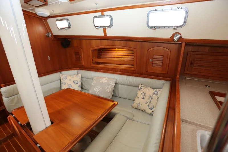Slide: The Image of Cozy interior of 2004 Pacific Seacraft 40 sailboat with wooden finishes and cushioned seating. - 17