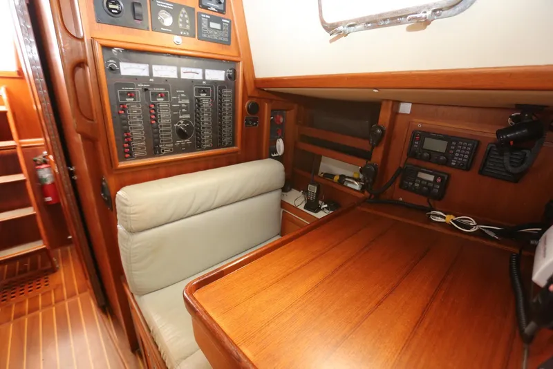 Slide: The Image of Navigation station of 2004 Pacific Seacraft 40 sailboat with control panels and seating. - 22