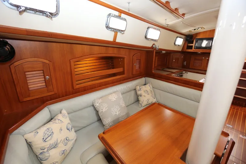 Slide: The Image of Cozy interior of 2004 Pacific Seacraft 40 sailboat with wooden finishes and cushioned seating. - 30