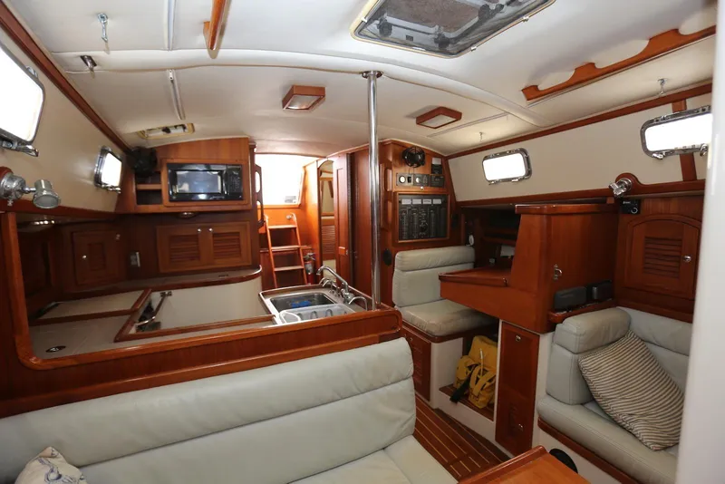 Slide: The Image of Interior of 2004 Pacific Seacraft 40 sailboat, featuring cozy seating and wooden cabinetry. - 33