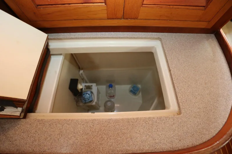 Slide: The Image of Storage compartment in 2004 Pacific Seacraft 40 yacht, featuring countertop and wooden cabinetry. - 37