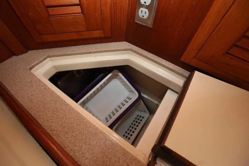 Slide: The Image of Storage compartment in 2004 Pacific Seacraft 40 sailboat with wooden cabinetry and electrical outlet. - 38