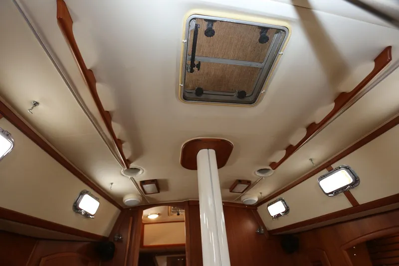 Slide: The Image of Interior ceiling of 2004 Pacific Seacraft 40 sailboat, featuring wooden accents and portholes. - 48