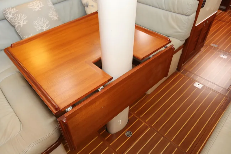 Slide: The Image of Interior of 2004 Pacific Seacraft 40 sailboat with wooden table and cushioned seating. - 50