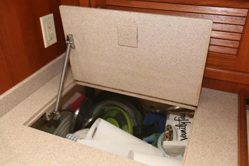 Slide: The Image of Storage compartment in a 2004 Pacific Seacraft 40 yacht, containing kitchen items and paper towels. - 55
