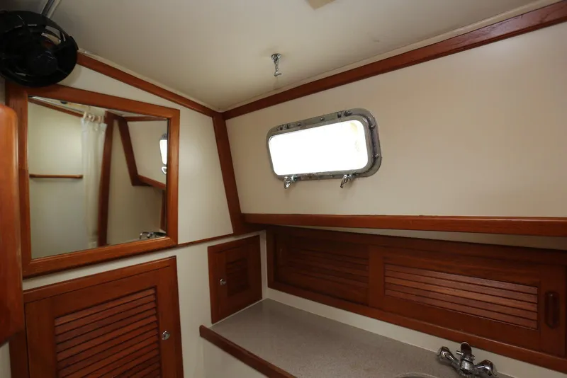 Slide: The Image of Bathroom interior of 2004 Pacific Seacraft 40 yacht with wooden accents and porthole window. - 61