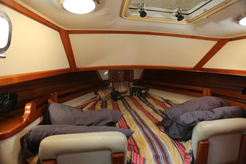 Slide: The Image of Cozy cabin interior of 2004 Pacific Seacraft 40 sailboat with striped bedding and wooden accents. - 77
