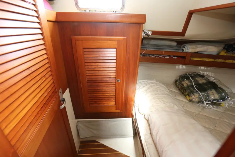 Slide: The Image of Cozy cabin interior of 2004 Pacific Seacraft 40 sailboat with wooden cabinetry and bedding. - 79