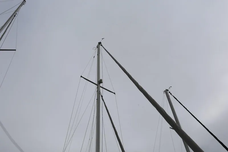 Slide: The Image of Masts of a 2004 Pacific Seacraft 40 sailboat against a cloudy sky. - 9