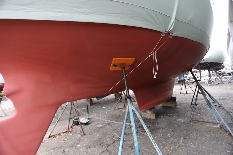 Slide: The Image of Red hull of a 2004 Pacific Seacraft 40 sailboat on stands. - 94