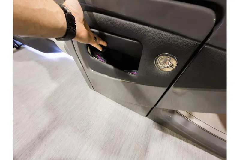 Slide: The Image of Hand accessing storage compartment in 2026 Godfrey Monaco 235 Ultra Lounge boat. - 17