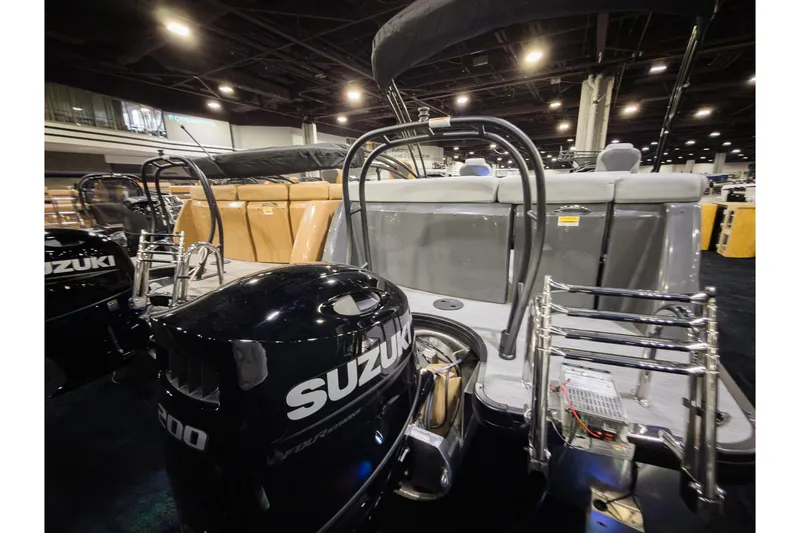 Slide: The Image of 2026 Godfrey Monaco 235 Ultra Lounge boat with Suzuki outboard engines displayed indoors. - 3