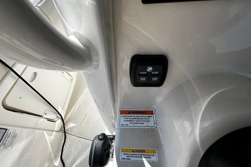 Slide: The Image of Control panel and warning labels on 2022 Boston Whaler 280 Outrage boat. - 12