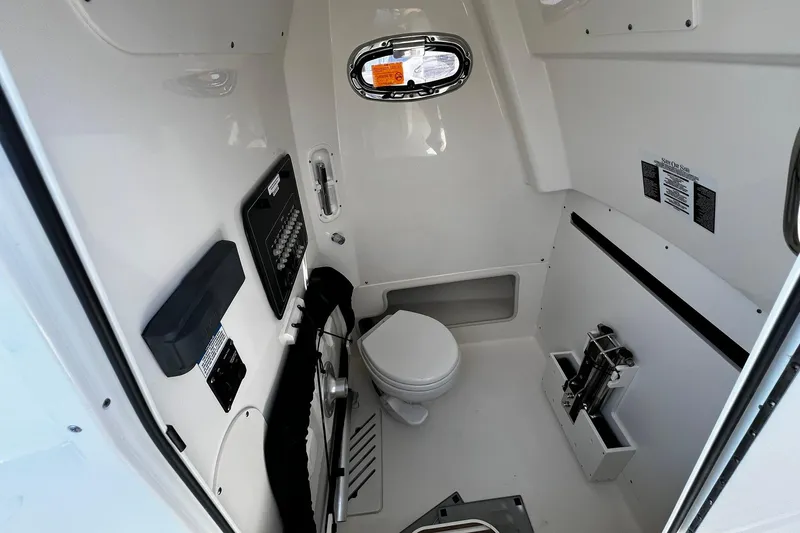 Slide: The Image of Interior of 2022 Boston Whaler 280 Outrage boat, featuring a compact marine toilet. - 16