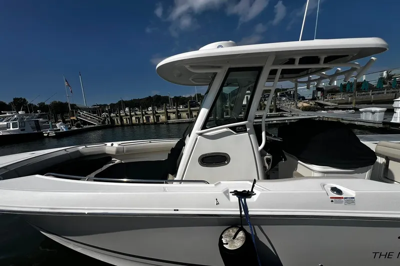 Slide: The Image of 2022 Boston Whaler 280 Outrage docked at marina under clear blue sky. - 2