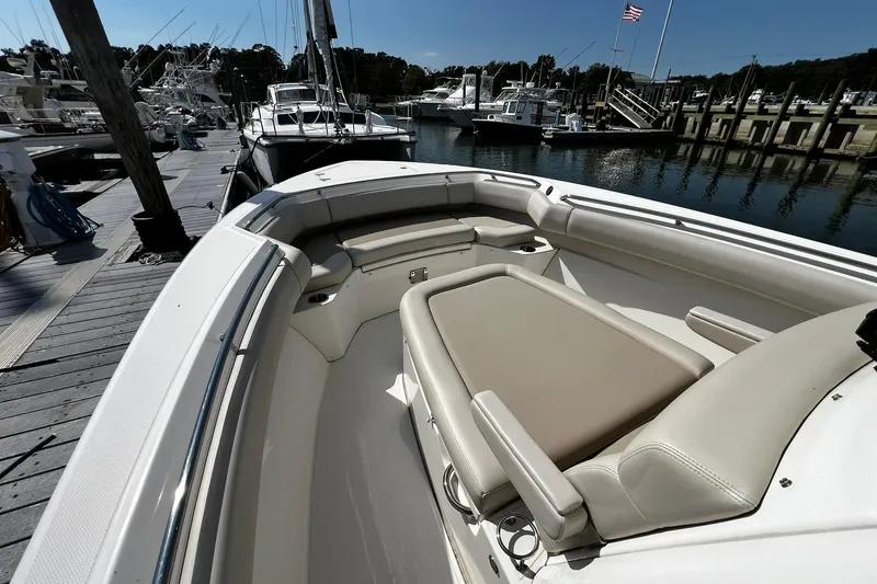 Slide: The Image of 2022 Boston Whaler 280 Outrage boat interior at marina, showcasing seating and deck layout. - 21