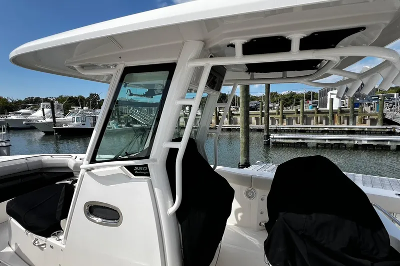 Slide: The Image of 2022 Boston Whaler 280 Outrage boat docked at marina, showcasing sleek design and spacious interior. - 24