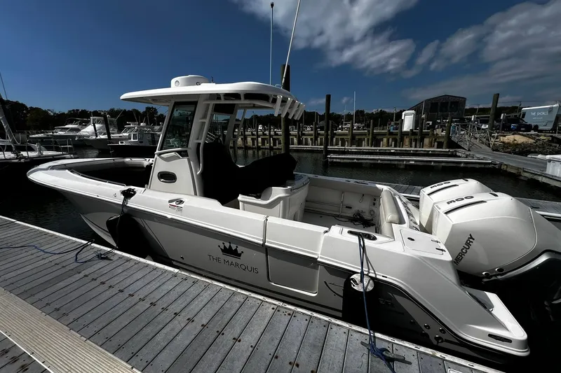 Slide: The Image of 2022 Boston Whaler 280 Outrage boat docked at marina under blue sky. - 3
