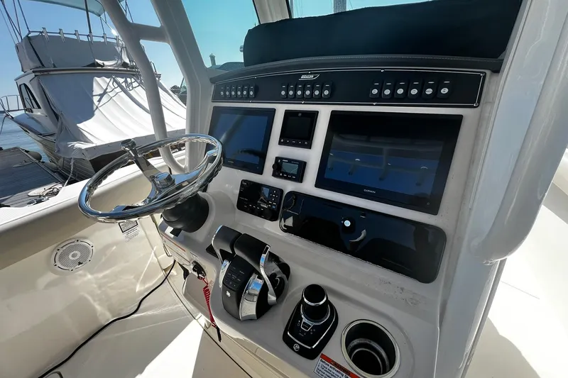 Slide: The Image of Control panel of 2022 Boston Whaler 280 Outrage boat with steering wheel and navigation screens. - 8