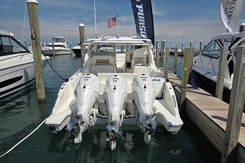 Slide: The Image of 2026 Pursuit DC 365 Dual Console boat docked with triple 350 V8 engines. - 1