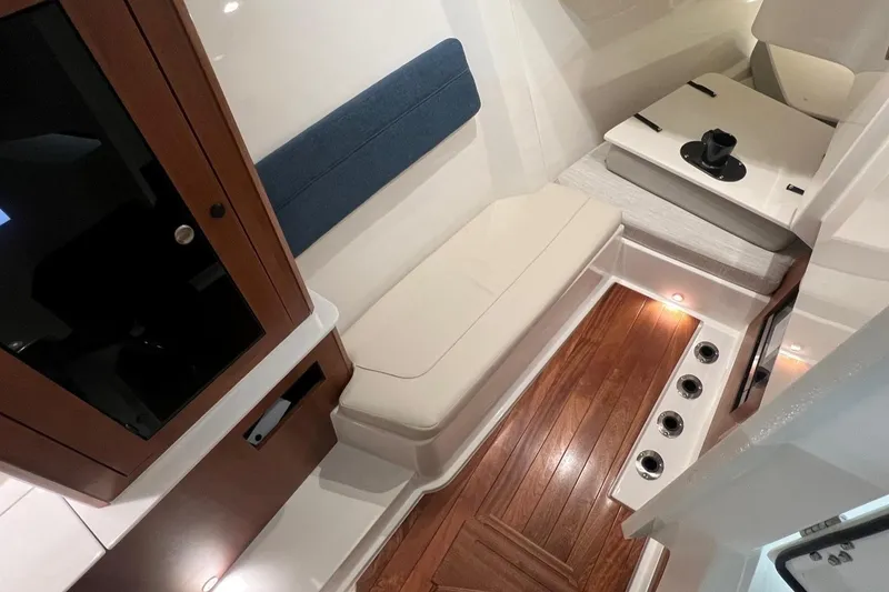 Slide: The Image of Interior of 2026 Pursuit DC 365 Dual Console with wood flooring and cushioned seating. - 16