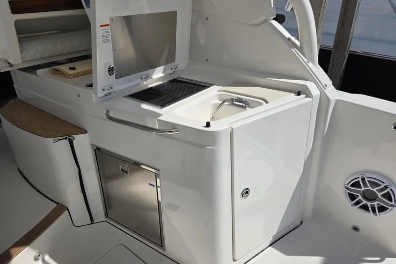 Slide: The Image of 2026 Pursuit DC 365 Dual Console boat interior with sink and storage area. - 18