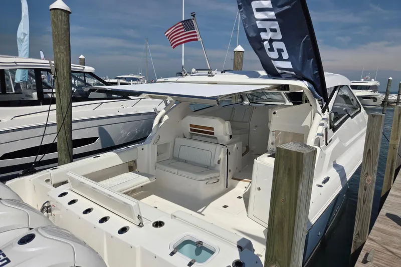 Slide: The Image of 2026 Pursuit DC 365 Dual Console boat docked, showcasing spacious seating and sleek design. - 2