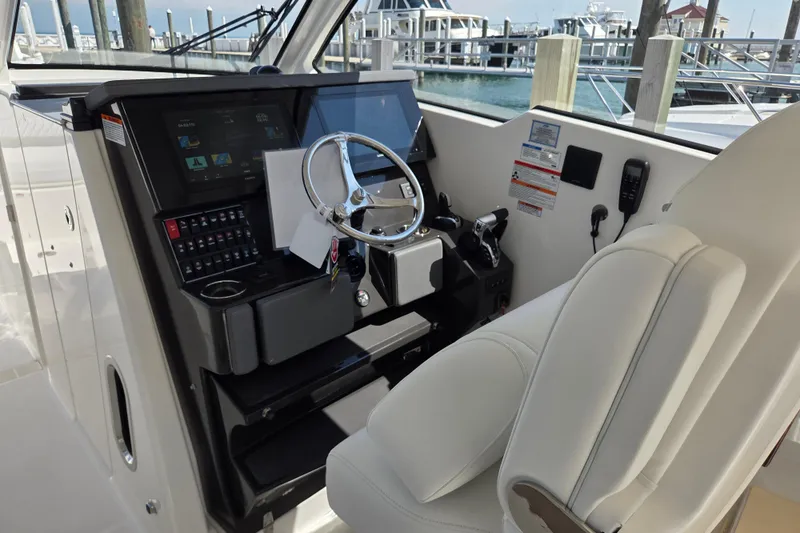 Slide: The Image of Helm of 2026 Pursuit DC 365 Dual Console boat with modern controls and steering wheel. - 20