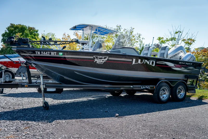 Slide: The Image of 2006 Lund 2025 Pro-V Magnum SE boat on trailer, outdoors, with Honda engines. - 1