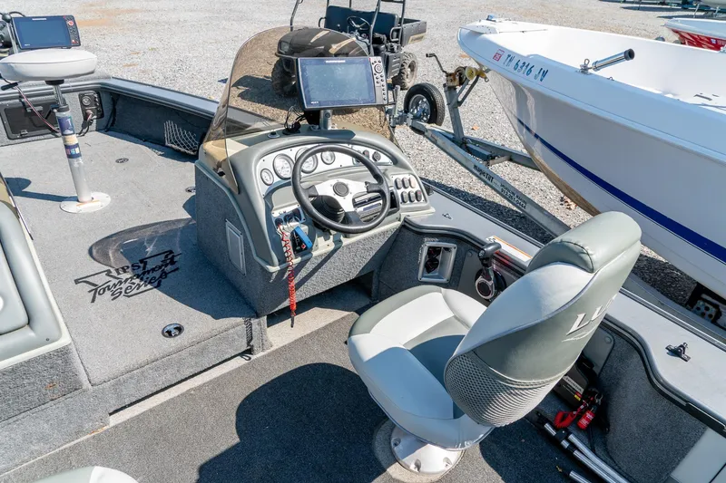 Slide: The Image of 2006 Lund 2025 Pro-V Magnum SE boat interior with steering wheel and navigation equipment. - 13