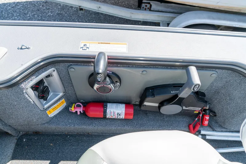 Slide: The Image of 2006 Lund 2025 Pro-V Magnum SE boat controls with fire extinguisher and safety equipment. - 15