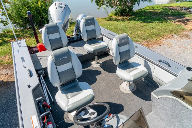 Slide: The Image of 2006 Lund 2025 Pro-V Magnum SE boat interior with four seats, steering wheel, and motor. - 21
