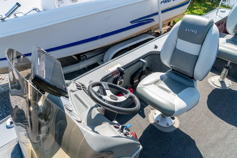 Slide: The Image of 2006 Lund 2025 Pro-V Magnum SE boat interior with steering wheel and seating. - 23