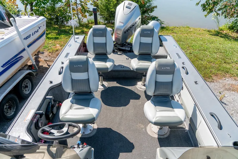 Slide: The Image of 2006 Lund 2025 Pro-V Magnum SE boat interior with four seats and Honda outboard motor. - 25