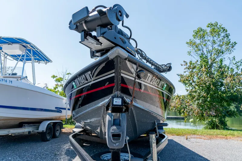 Slide: The Image of 2006 Lund 2025 Pro-V Magnum SE boat on trailer near lake and trees. - 4