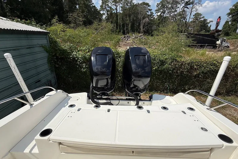 Slide: The Image of 2017 Boston Whaler 270 Dauntless with dual outboard engines, parked near greenery. - 10